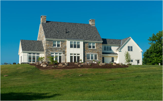 Hilltop home in Salisbury NH incorporating stone construction with a sunroom overlooking the mountains